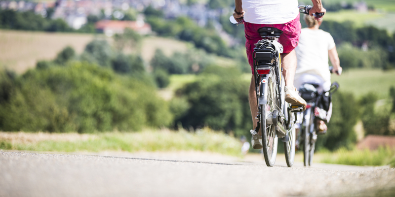 Twee fietsers met elektrische batterij achterop dalen een berg af