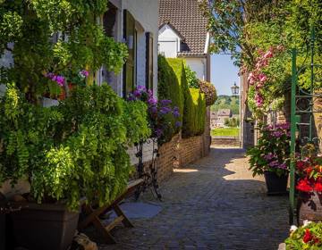 De Batsteeg met kleurrijke bloemen in Eijsden