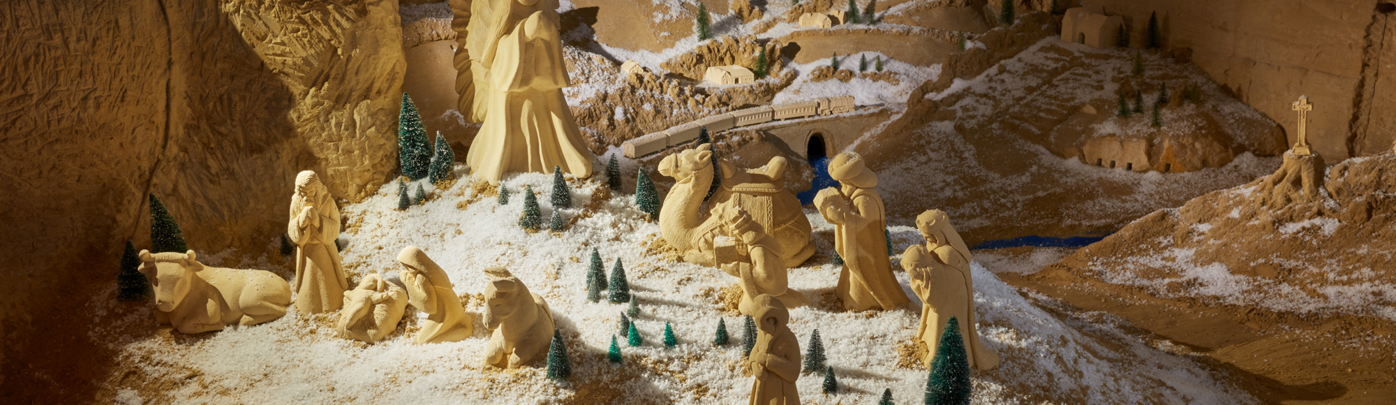 Een besneeuwd mergellandschap met een kerststalletje van mergelsculpturen