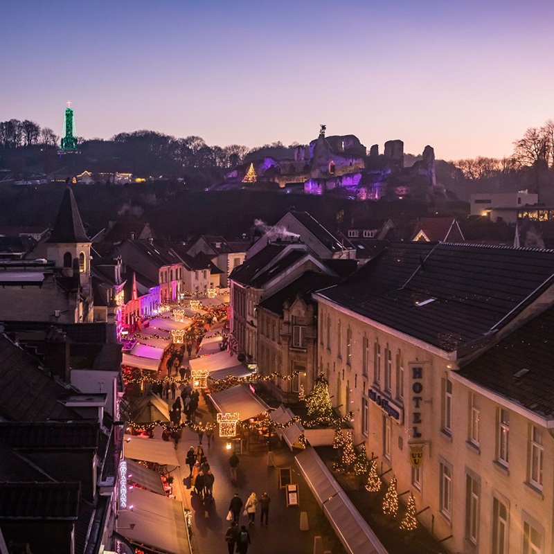 Avondfoto van Valkenburg vanaf de Geulpoort met verlichte straatjes en terrassen