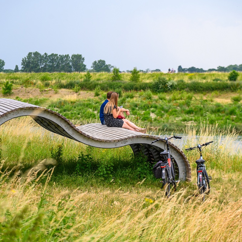 Een koppel pauzeert op een kunstwerk langs de Maas